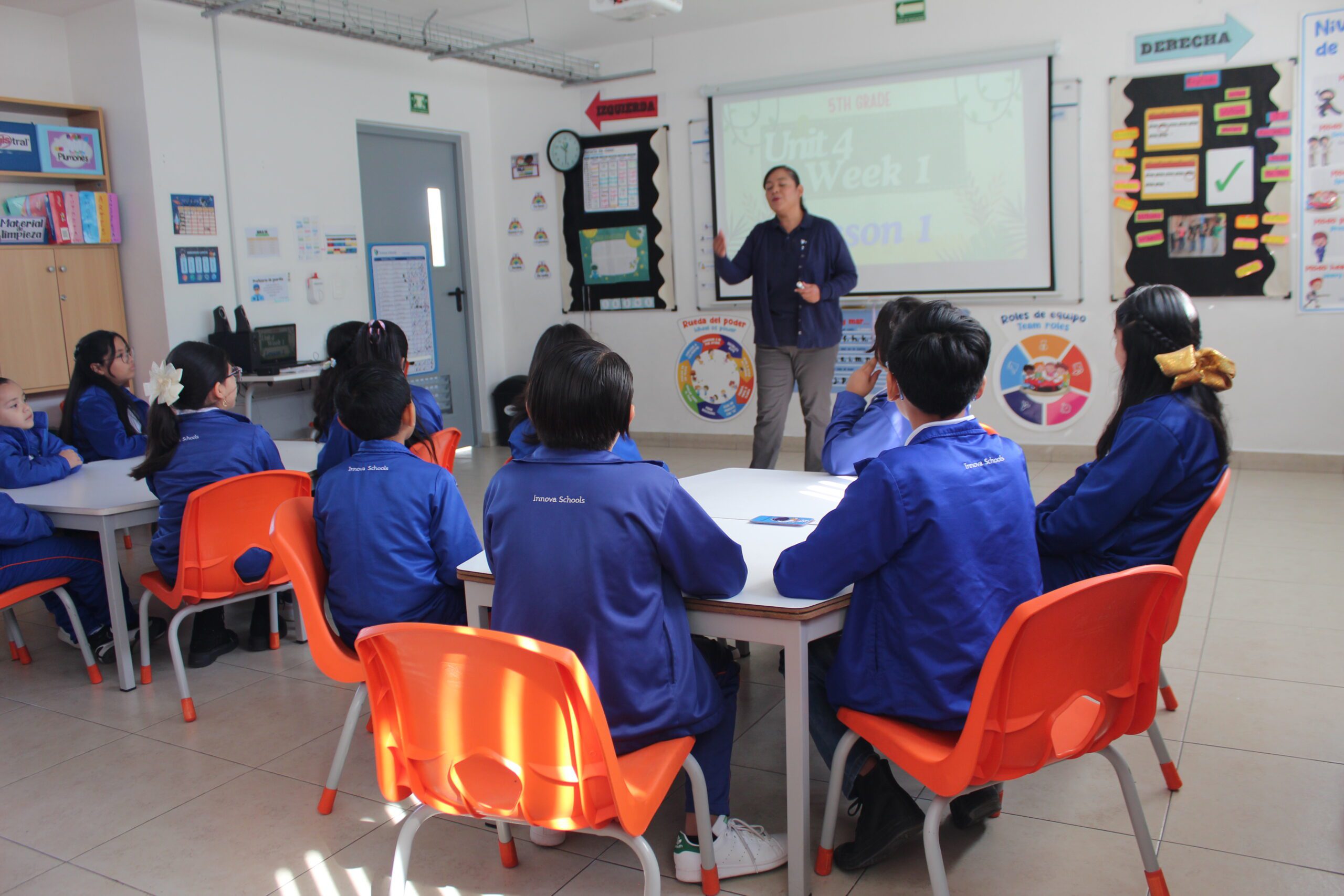alumnos sentados al rededor de una mesa en clase de inglés