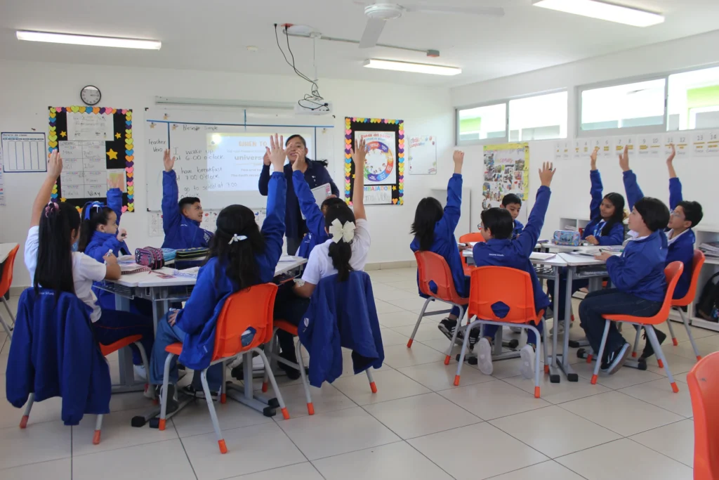 niños alzando la mano en clase de inglés