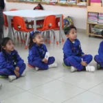 niños de kinder sentados en el salón de clases