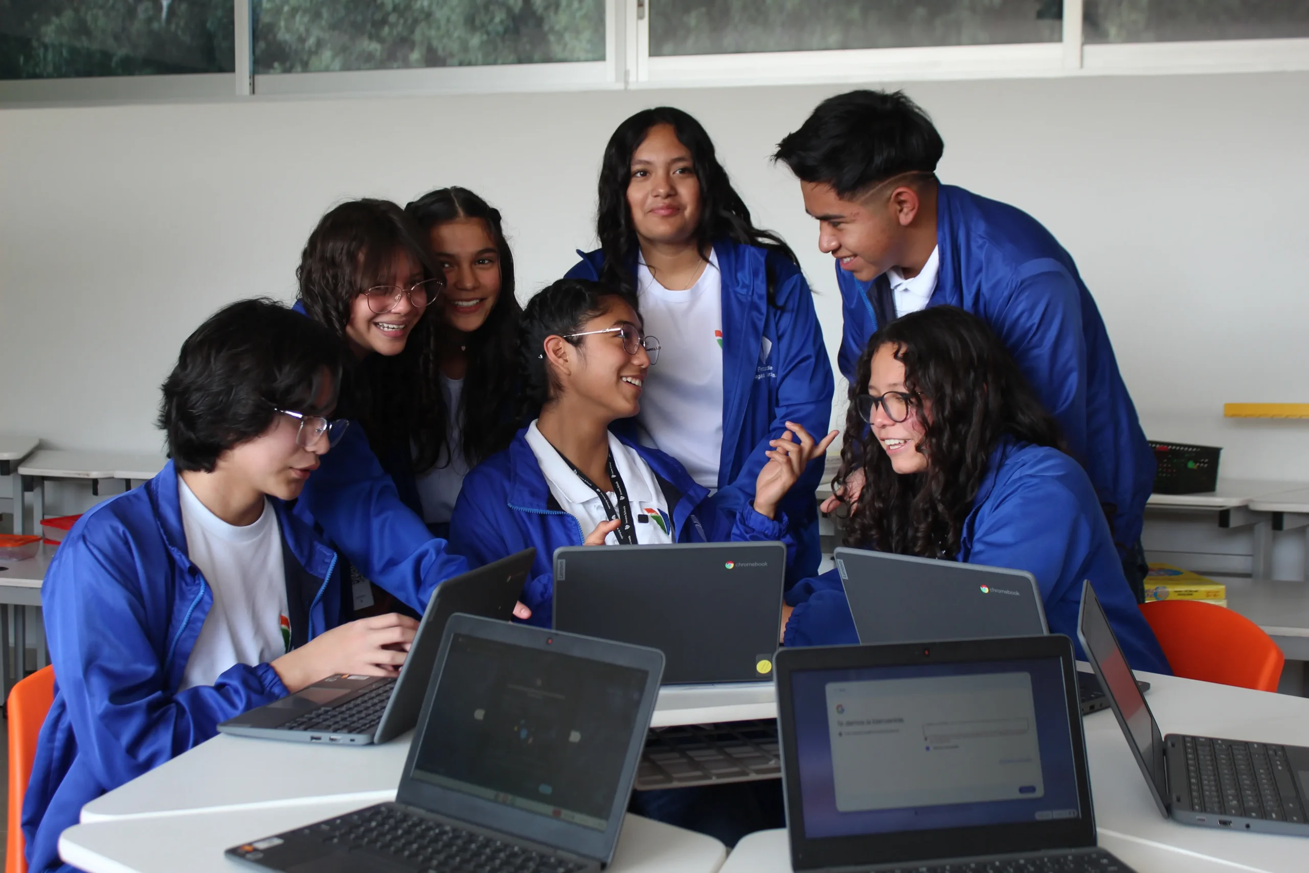 estudiantes reunidos al rededor de una laptop